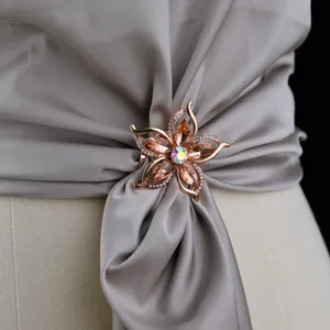 Vista dettagliata dell'elegante clip per sciarpa e spilla a fiore in cristallo oro rosa.