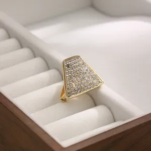 Detailed view of a glittering rhinestone triangular scarf ring, gold metal buckle for ties.