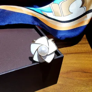 Détail d'anneau de foulard fleur émaillée, élégante boucle en perle pour châles et foulards de mode.