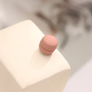Close-up detail view of a minimalist pink round magnetic hijab pin, showing smooth surface.