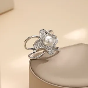 Dettaglio di fibbia per sciarpa camelia in strass con perla e cristalli luminosi.