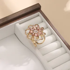 Primo piano di una fibbia floreale dorata con strass brillanti in un elegante cofanetto.