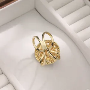 Primo piano della fibbia per sciarpa a camelia dorata con strass su vassoio di velluto bianco.