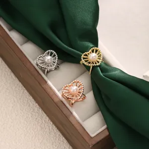Vue de détail de la petite boucle de foulard en cœur perle, anneau métallique élégant chemise.