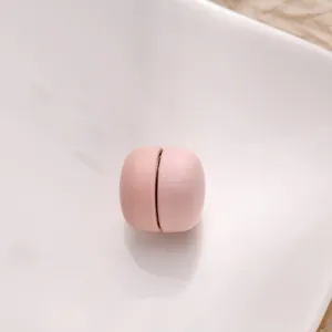Close-up van een roze magnetische kledingknop, mat afgewerkt, minimalistisch detail.
