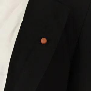 Close-up detail van een ronde bruine magnetische anti-glans broche op zwarte reversstof.