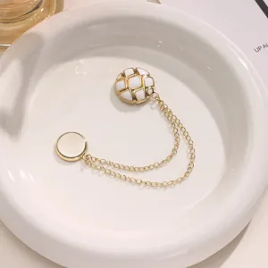 Chic magnetic pants hem fixing clip with gold chains and white quilted design, elegant decor.