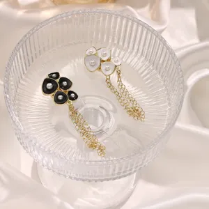 Detail shot of stylish magnetic metal pant hem clips with flower and chain design.