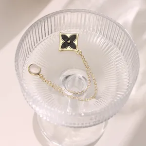 Magnetic trouser cuff shortener clip, golden chain and clover design for adjustable clothing length.