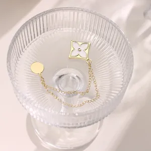 Detail shot of magnetic pants shortening clip chain with white flower charm, elegant and practical.
