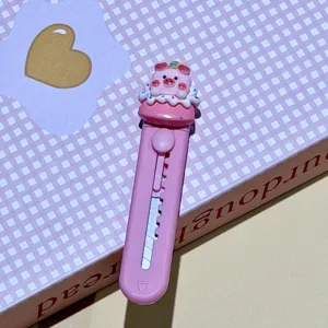 Vista detallada del mini cúter de cerdo rosa, cuchillo utilitario portátil para paquetes.