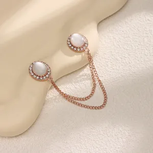 Rose gold magnetic clothing clip with white cat eye stones and double chains for scarf or pants.