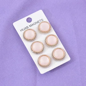 Set di 6 spille magnetiche rotonde e luminose per hijab con bordo dorato su carta.