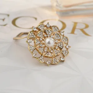 Detailed shot of a gorgeous gold alloy rhinestone pearl brooch scarf buckle, elegant floral design.