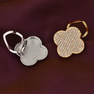 Detail view of rhinestone clover scarf clip and brooch, gold and silver alloy design.