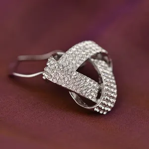 Rhinestone crystal scarf clip brooch detail shot, sparkling alloy metal jewelry accessory, close up view.