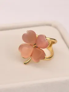 Close-up detail shot of a sweet pink four-leaf clover imitation cat's eye scarf ring in a box.