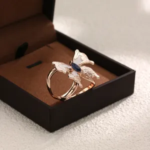 Nahaufnahme einer eleganten Schalspange mit Schmetterlings-Design, weißem Emaille und Stein.