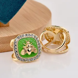 Close-up detail of a retro square bee scarf ring featuring sparkling rhinestones and green enamel.