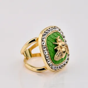 Close-up detail of the retro square gold scarf buckle with green quilted enamel and rhinestones.