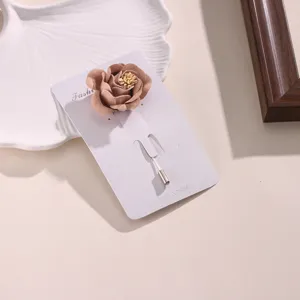 Squisita spilla con rosa in tessuto, primo piano dettagliato dal design floreale elegante.