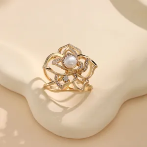 Elegant gold hollow flower scarf buckle with rhinestones and central pearl for women.