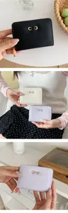 Women short bifold zipper wallet with metallic lock closure and multiple card slots.