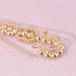 Spilla di sicurezza dorata con strass dettaglio ravvicinato, elegante fibbia per sciarpa e cappotto.