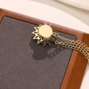 Gedetailleerd overzicht van de gouden zonnebloem magnetische broche met fijne kettingen op bord.