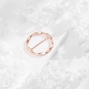 Detalle de hebilla de bufanda circular irregular en oro rosa, elegante anillo de esquina.