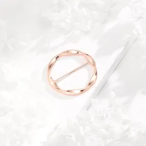 Primer plano de una hebilla de pañuelo redonda retorcida en oro rosa, accesorio elegante.