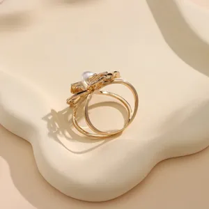 Exquisite gold scarf ring featuring a hollow flower design, pearl and sparkling crystals detail.