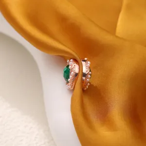 Detailopname van de roségouden magnetische hijabspeld met groen kristal en fijne parels.