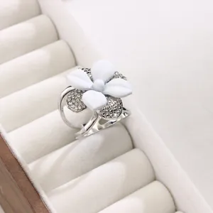 Dettaglio della fibbia per sciarpa floreale bianca elegante con strass e doppio anello.