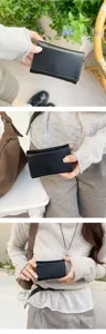 Primo piano dettagliato di un piccolo portafoglio nero compatto a tre ante tenuto in mano.