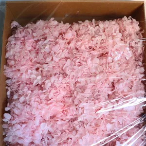 Detailed view of pink preserved hydrangea flower petals, bulk packed in a box for DIY crafts.