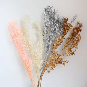 Rami di foglie secche conservate colorate per decorazione floreale di nozze fai da te.
