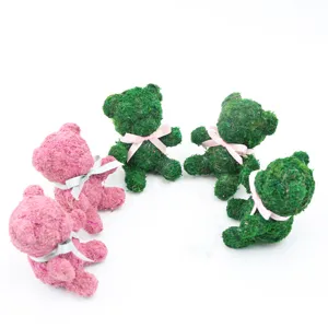Preserved moss bear detail closeup, cute green and pink animal figurine with nice ribbon.