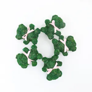 Detail shot of green moss bear figurines with pink ribbons, perfect for DIY floral crafts.