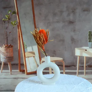Dried Banksia flower bouquet with white ceramic ring vase for elegant home decor and photography.