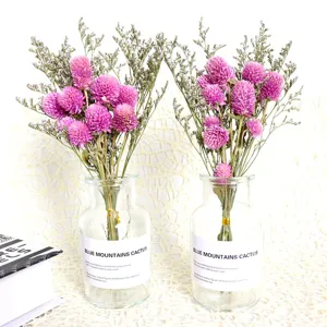 Dried flower bouquet with globe amaranth and statice in glass bottle for home decor gift.