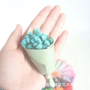 Close-up detail of mini preserved baby's breath flower bouquet in hand for cute gift decor.