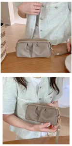 Vista dettagliata della pochette doppia in pelle PU grigio-marrone con comodo cinturino da polso.