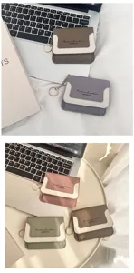 Detailed view of mini two-tone coin purses with keychain, lifestyle flat lay on desk.