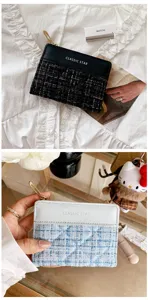 Vue détaillée d'un portefeuille élégant en tweed avec fermeture éclair et style chic.