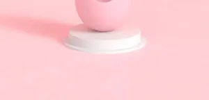Detail view of the pink cat toy tumbler container on white podium, clean minimalist pet supply.