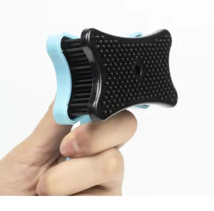 Detail close-up of the pet grooming brush featuring black pin bristles and blue base.