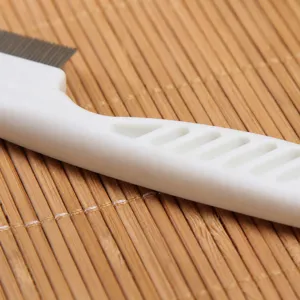Pet grooming comb with white plastic handle and metal teeth for dogs and cats daily care.