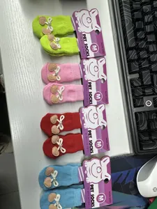 Detailed close-up view of colorful non-slip pet socks featuring cute bows and size cards.