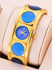 Gold cuff quartz watch with blue dial and circular inlay details, elegant women wrist watch.